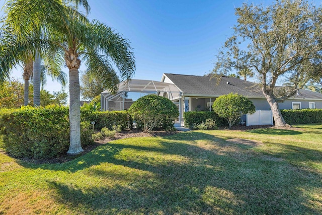 view of front of property with a front lawn and glass enclosure