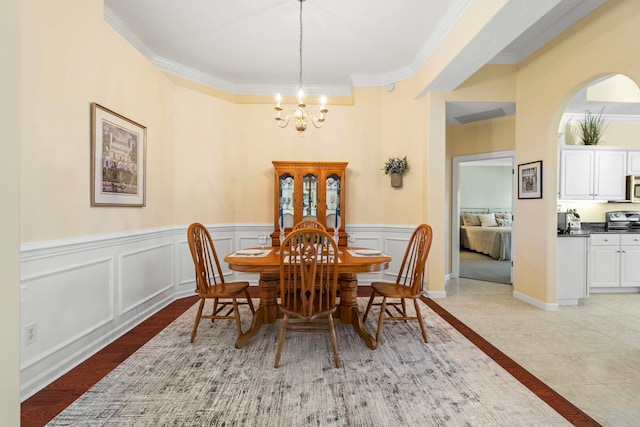 dining space with ornamental molding and an inviting chandelier