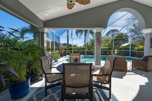 view of patio / terrace featuring ceiling fan and glass enclosure