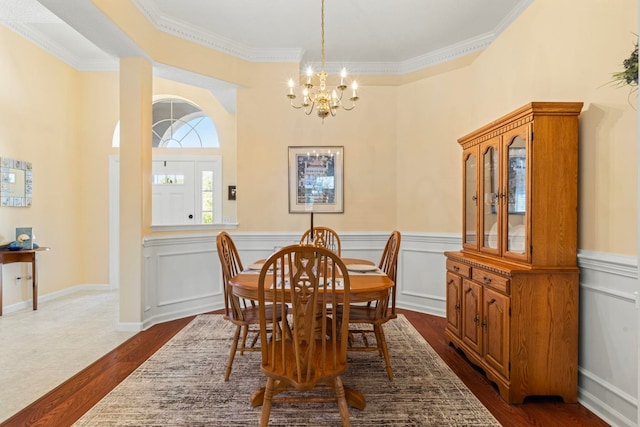 dining room featuring dark hardwood / wood-style flooring, crown molding, and an inviting chandelier