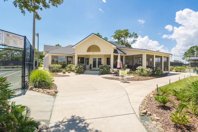 view of front of property featuring tennis court