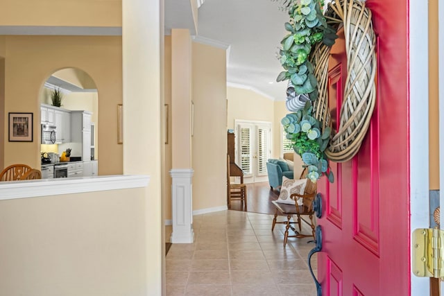 foyer with light tile patterned flooring, ornamental molding, and french doors