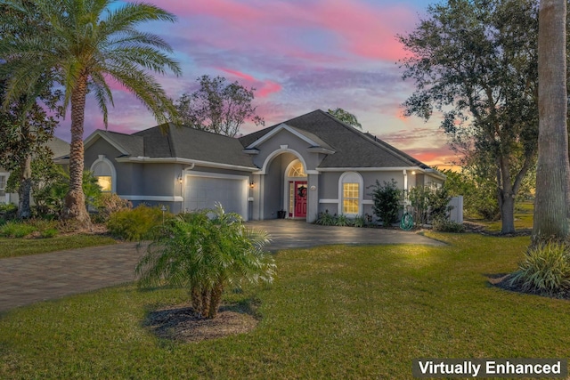 ranch-style house featuring a garage and a lawn