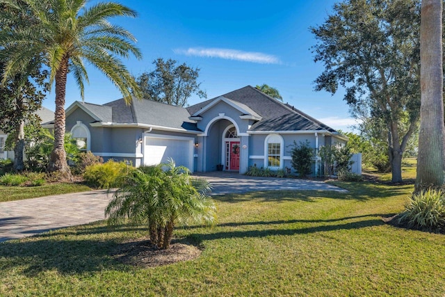 ranch-style house with a garage and a front lawn