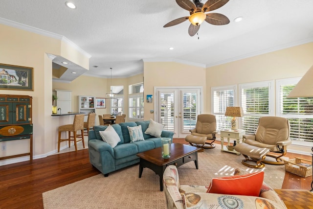 living room with french doors, lofted ceiling, crown molding, wood-type flooring, and a textured ceiling