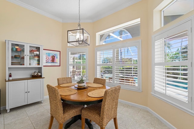 tiled dining area featuring an inviting chandelier and ornamental molding