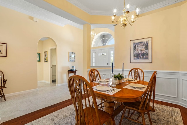 tiled dining room with an inviting chandelier and ornamental molding