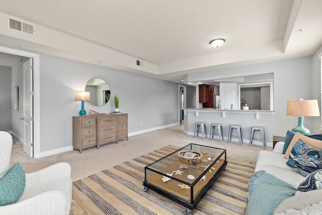 175 Laterra Links Cir Unit 101, Saint Augustine, FL 32092 - living area featuring baseboards, visible vents, and light colored carpet