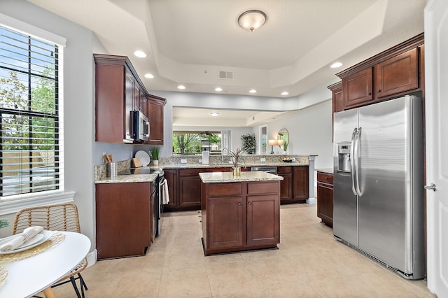 175 Laterra Links Cir Unit 101, Saint Augustine, FL 32092 - kitchen with a peninsula, a healthy amount of sunlight, visible vents, a raised ceiling, and appliances with stainless steel finishes