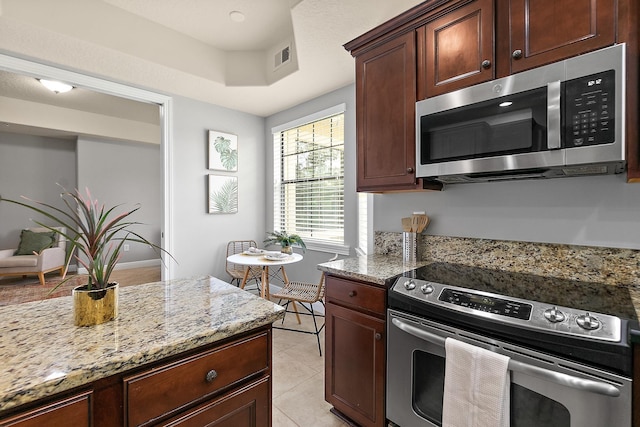 175 Laterra Links Cir Unit 101, Saint Augustine, FL 32092 - kitchen featuring light stone countertops, stainless steel appliances, light tile patterned floors, and visible vents