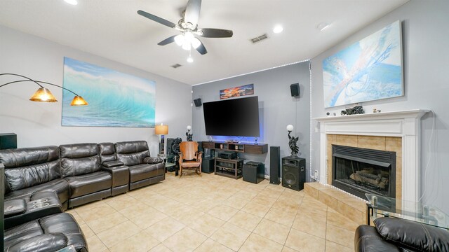 living room with light tile patterned floors, visible vents, ceiling fan, and a fireplace