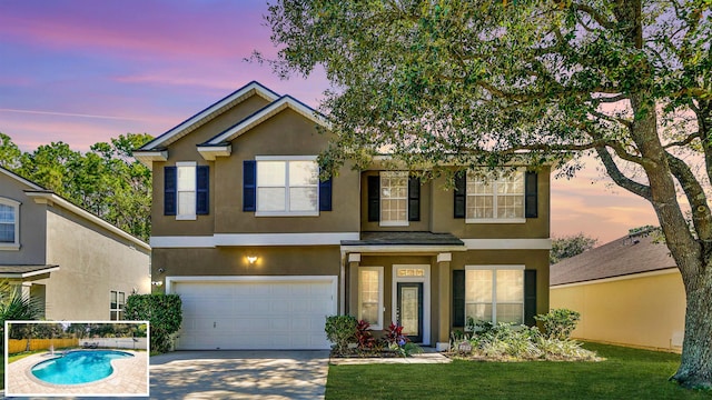 view of front of home with an outdoor pool, stucco siding, a garage, and driveway