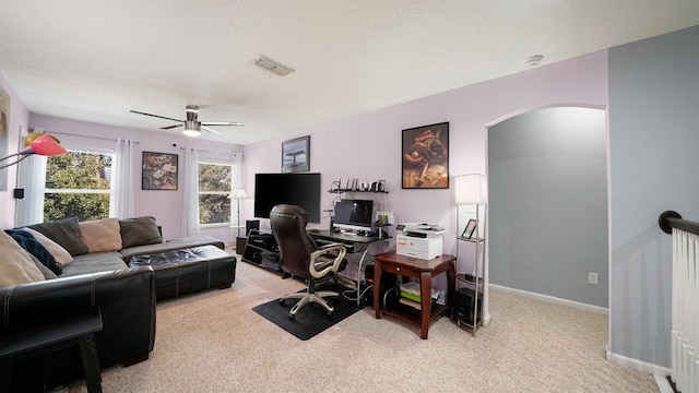 office space with baseboards, arched walkways, visible vents, and light carpet