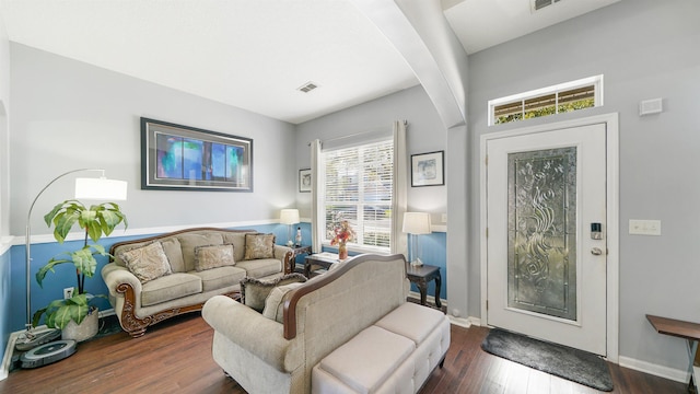 living room with visible vents, baseboards, and wood finished floors