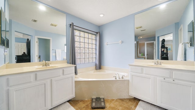 bathroom featuring tile patterned floors, a garden tub, two vanities, a sink, and a shower stall