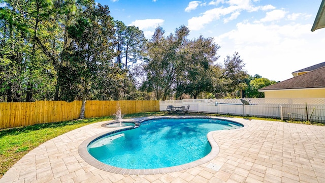 view of swimming pool with a patio area, a pool with connected hot tub, and a fenced backyard