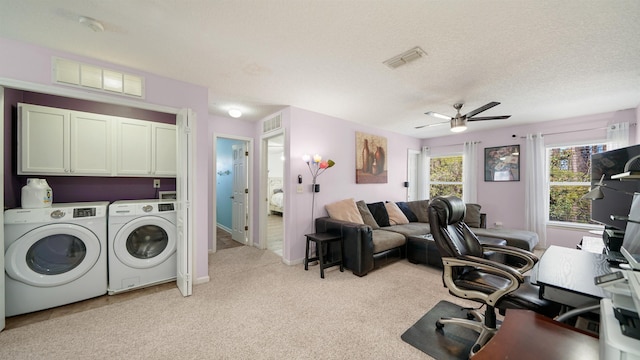 interior space featuring visible vents, light carpet, cabinet space, a textured ceiling, and independent washer and dryer