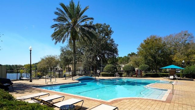 community pool with a patio and fence