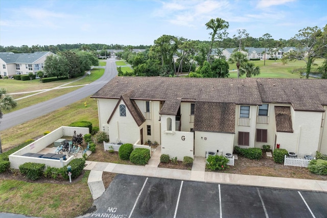 600 Domenico Cir Unit G9, Saint Augustine, FL 32086 - view of front of house featuring roof with shingles, uncovered parking, a residential view, and stucco siding