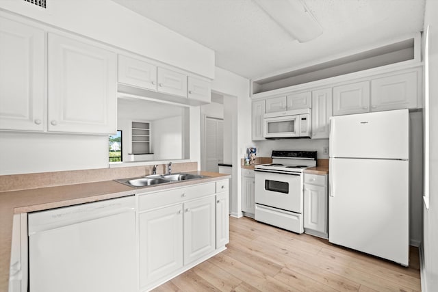 600 Domenico Cir Unit G9, Saint Augustine, FL 32086 - kitchen with white appliances, white cabinets, light wood-style flooring, and light countertops