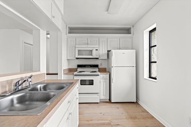 600 Domenico Cir Unit G9, Saint Augustine, FL 32086 - kitchen featuring white appliances, light wood-type flooring, white cabinetry, light countertops, and a textured ceiling