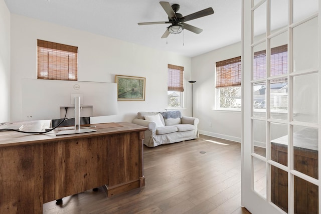 office featuring wood finished floors, a ceiling fan, and baseboards