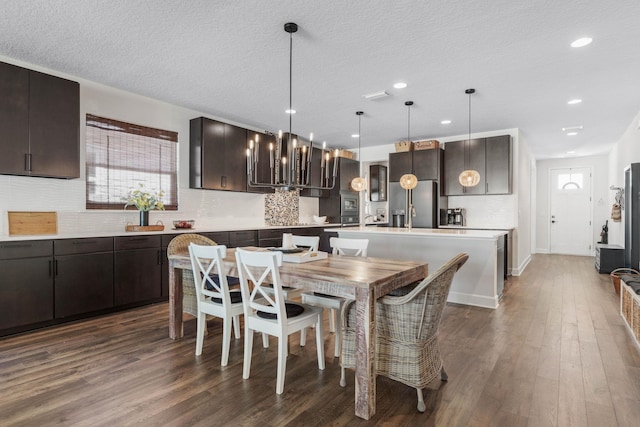 dining room featuring a textured ceiling, dark wood-type flooring, and recessed lighting