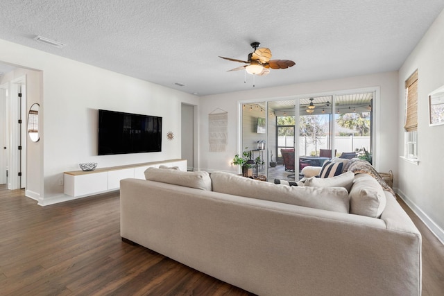 living room featuring dark wood-style floors, baseboards, and a textured ceiling