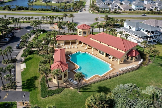 pool with a patio area, fence, a residential view, and a water view