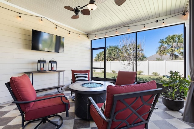 sunroom / solarium featuring ceiling fan and track lighting