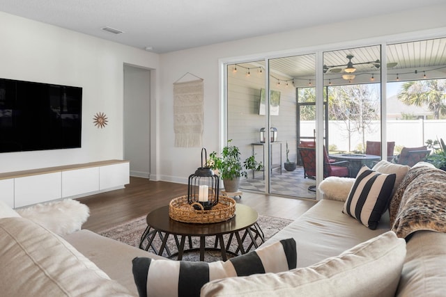 living room with visible vents, baseboards, and wood finished floors