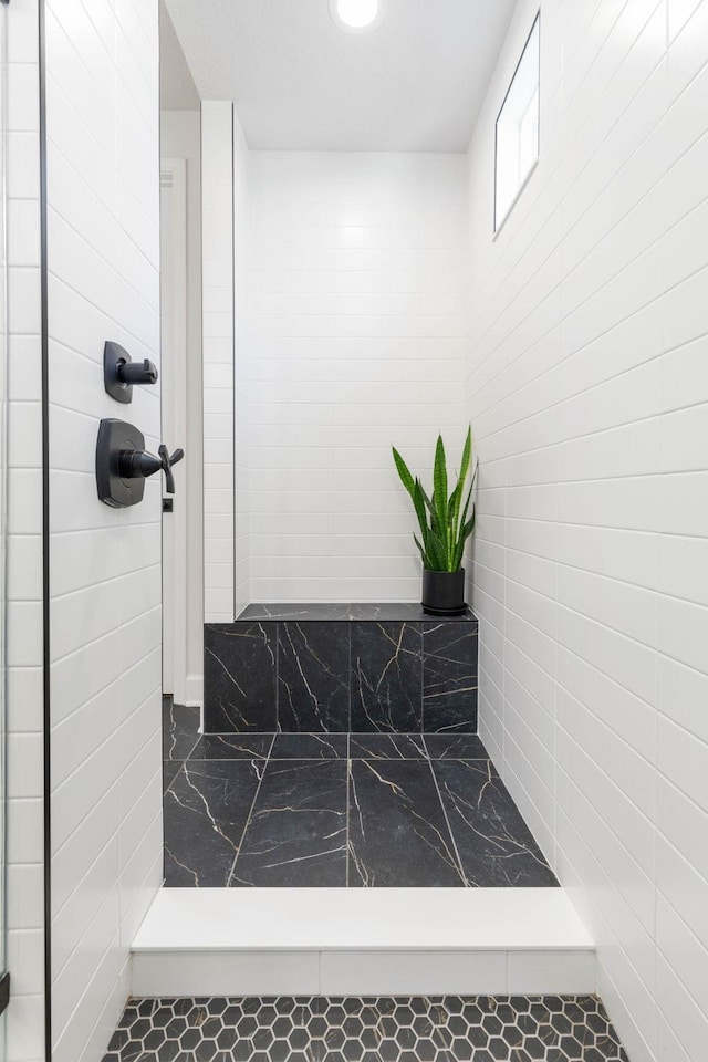 full bathroom featuring marble finish floor, a tile shower, and recessed lighting