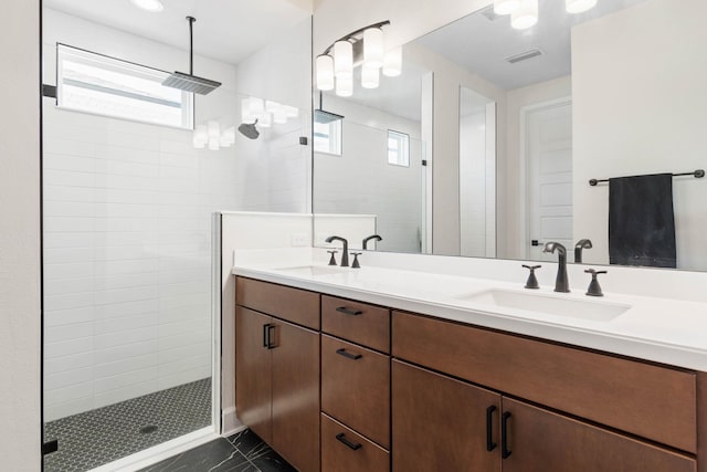 bathroom with double vanity, visible vents, a walk in shower, and a sink