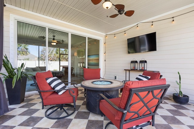 view of patio with ceiling fan, an outdoor fire pit, and fence