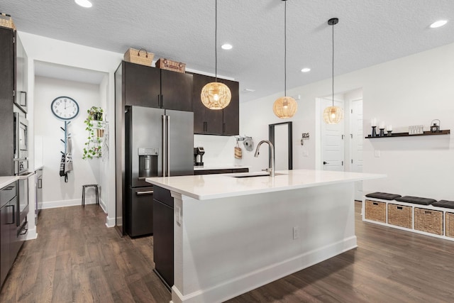 kitchen with dark wood-style floors, light countertops, high quality fridge, and a sink