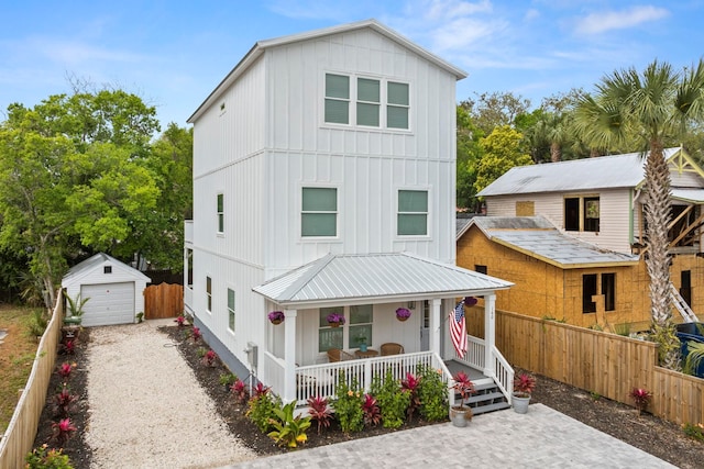 view of front of home featuring covered porch, a garage, and an outdoor structure