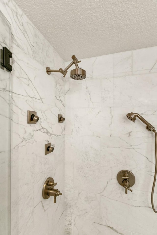 interior space featuring a tile shower and a textured ceiling