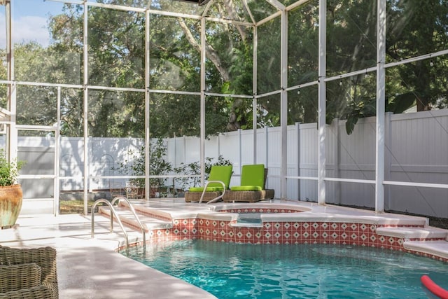 view of swimming pool with an in ground hot tub, a patio, and glass enclosure