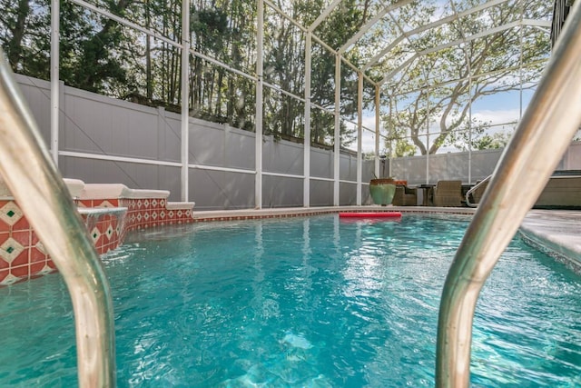 view of swimming pool featuring a lanai