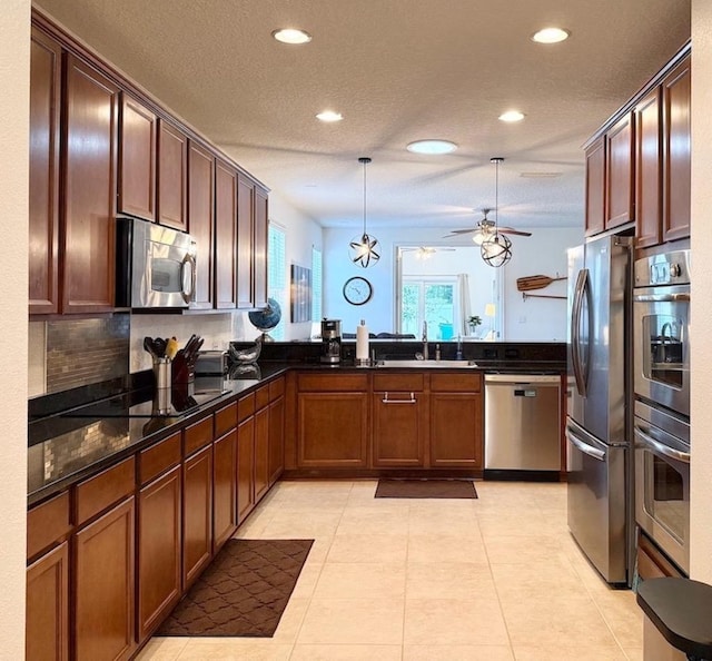 kitchen featuring stainless steel appliances, a peninsula, recessed lighting, a ceiling fan, and a sink