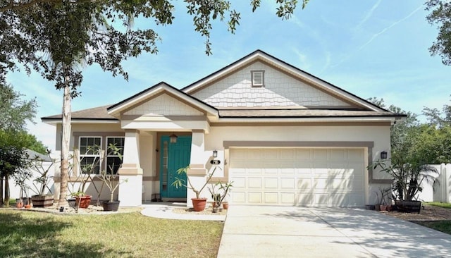 view of front facade featuring an attached garage, driveway, stucco siding, a front lawn, and roof with shingles
