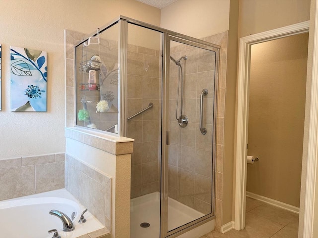 full bath featuring a shower stall, a bath, and tile patterned floors