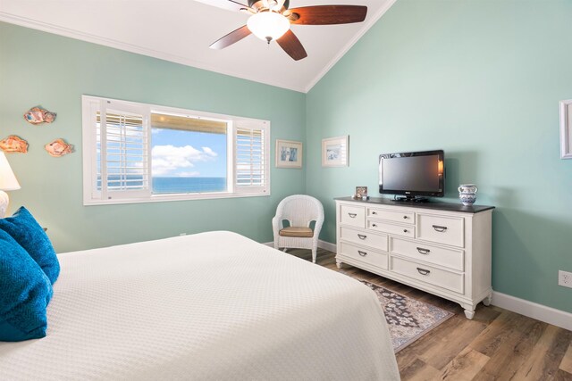 bedroom with a ceiling fan, baseboards, vaulted ceiling, light wood finished floors, and crown molding