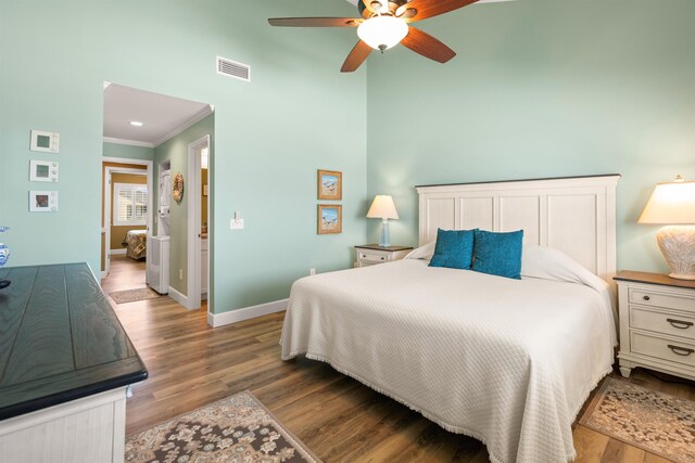 bedroom featuring ornamental molding, baseboards, visible vents, and light wood finished floors