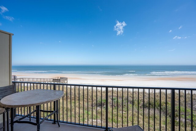 balcony featuring a water view and a beach view