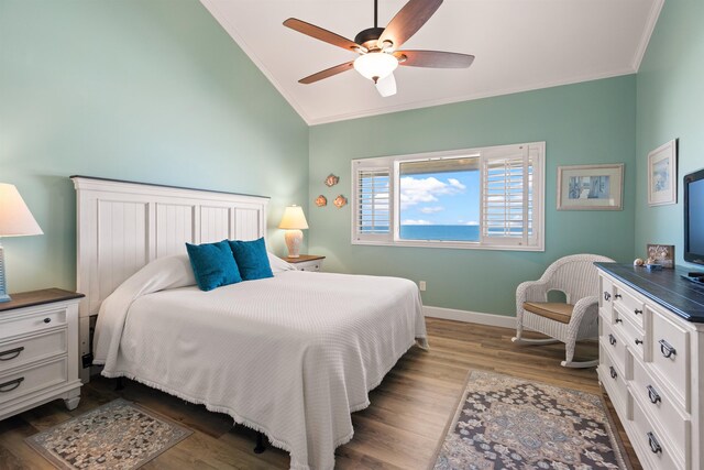 bedroom featuring crown molding, light wood-style floors, vaulted ceiling, ceiling fan, and baseboards