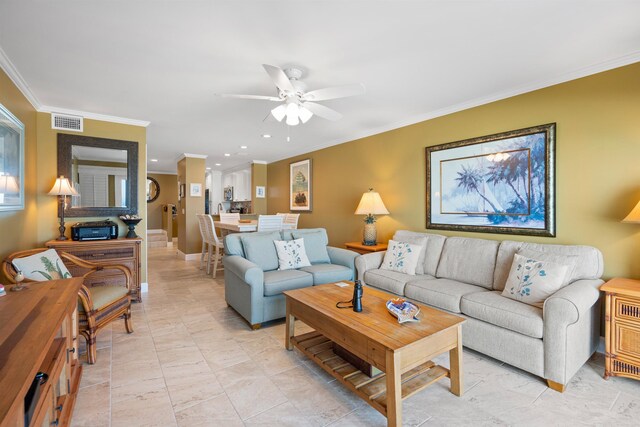 living room with baseboards, ceiling fan, visible vents, and crown molding