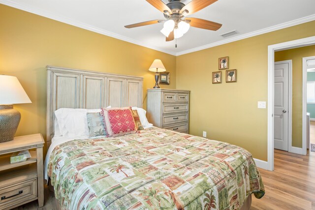 bedroom with ornamental molding, visible vents, light wood-style floors, and baseboards