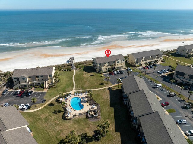 drone / aerial view featuring a water view, a residential view, and a view of the beach