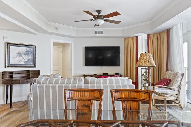 living room featuring ornamental molding, light hardwood / wood-style floors, and ceiling fan